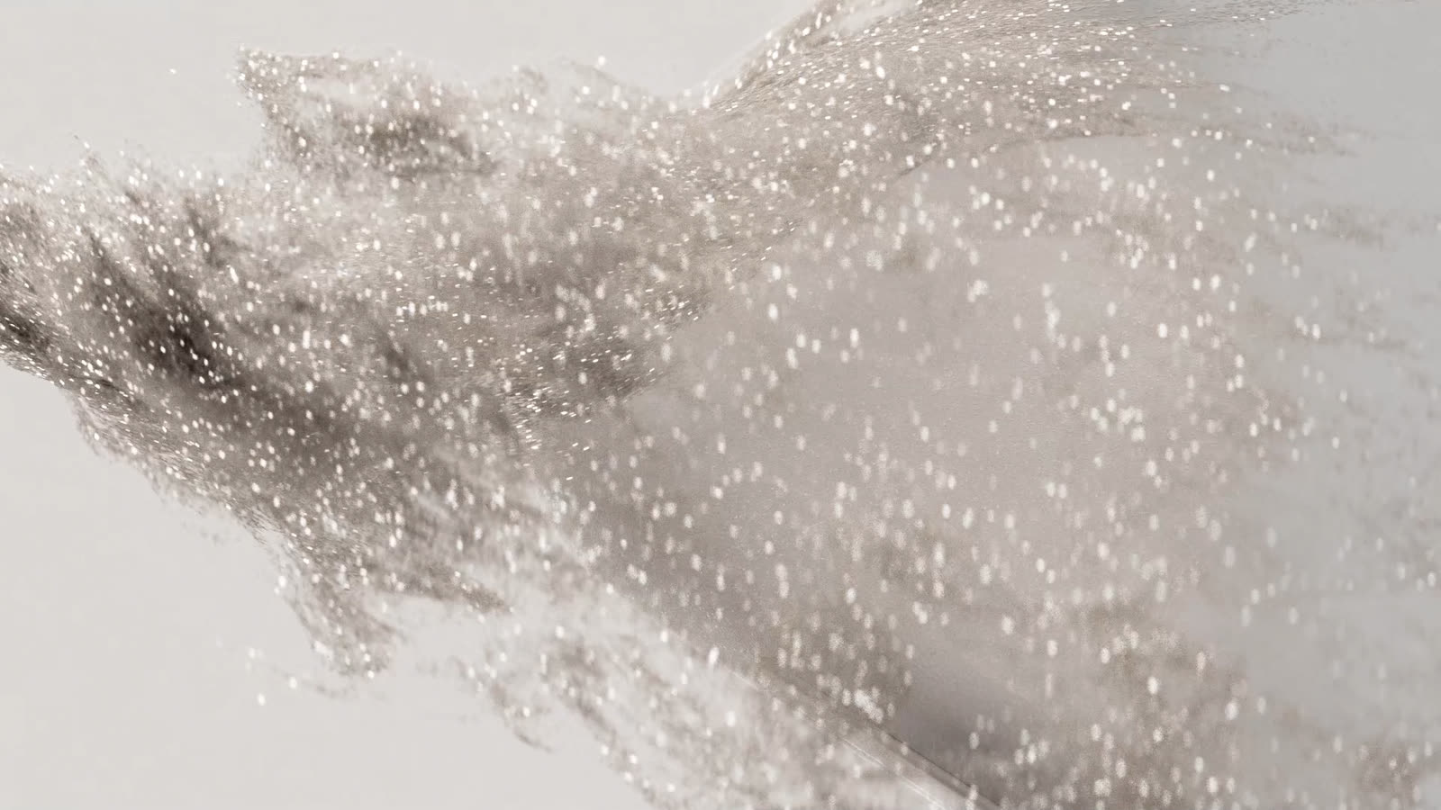 Fine powder particles converging and settling onto the tablet surface