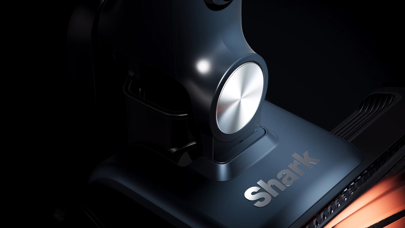 A Shark stick vac lit deep and moody, chrome hub and metallic trim catching the light